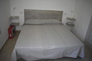 a large bed in a bedroom with a wooden headboard at Da Nonna Laura al Circeo in San Felice Circeo
