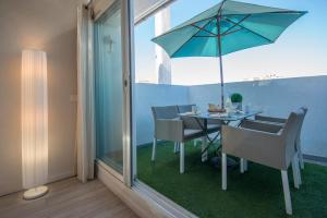 uma mesa de jantar com um guarda-sol azul e cadeiras em O Carré Croisette Cannes em Cannes