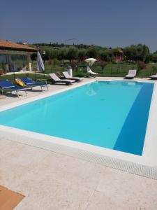 a large swimming pool with blue water at Villa Claudia in Bardolino