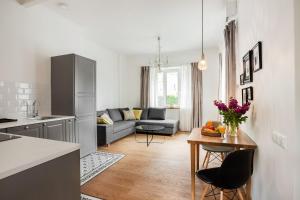 a kitchen and living room with a couch and a table at Bright and Cosy 1BDR apartment Kaunas Centre in Kaunas