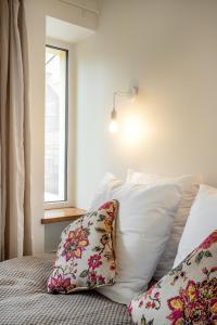 a bedroom with a bed with pillows and a window at Bright and Cosy 1BDR apartment Kaunas Centre in Kaunas