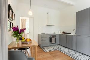 a kitchen with a wooden table and a tableasteryasteryasteryasteryasteryasteryastery at Bright and Cosy 1BDR apartment Kaunas Centre in Kaunas +32 photos