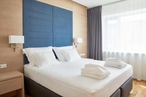 a bedroom with a large bed with two towels on it at Tallink Spa & Conference Hotel in Tallinn