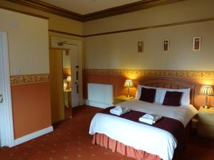 um quarto de hotel com uma cama grande e duas lâmpadas em Dumfries Villa em Dumfries