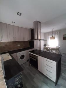 kuchnia z białymi szafkami i pralką i suszarką w obiekcie Casa aragon w mieście Boadilla del Monte