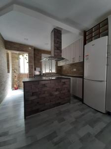uma cozinha com um frigorífico branco e uma parede de tijolos em Casa aragon em Boadilla del Monte