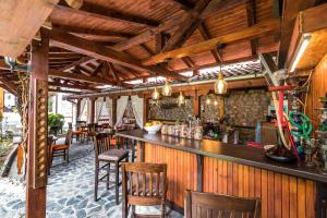 a bar in a restaurant with wooden ceilings and chairs at Hotel Ida in Bansko