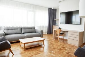 a living room with a couch and a tv at Tallink Spa & Conference Hotel in Tallinn +63 photos