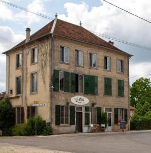 an old building with green shutters on a street at Le Voilà in Melay