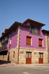 um edifício roxo ao lado de uma rua em Posada El Arrabal em Arenas de Iguña