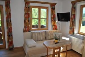 een woonkamer met een bank en een tafel bij Familienbauernhof Glockriegl in Lunz am See