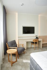 a room with a tv and a chair and a desk at Tallink Spa & Conference Hotel in Tallinn