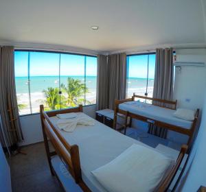 a bedroom with two beds and a view of the beach at Maraga Beach Hostel in Maragogi