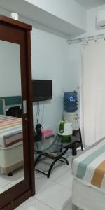 a living room with a glass table and a bed at Apartment Kota Ayodhya - Christine in Tangerang