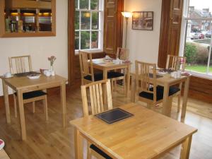 a dining room with wooden tables and chairs at Dumfries Villa in Dumfries