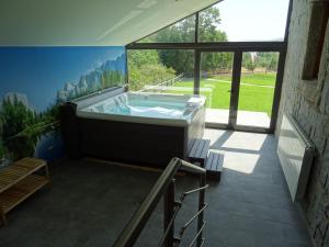 bañera grande en una habitación con ventana grande en CicloLodge, en Lozoya