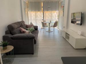 uma sala de estar com um sofá e uma mesa em Apartamento Dreamplace em Finestrat