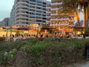 a group of people sitting at tables in front of a building at Apartamento Dreamplace in Finestrat