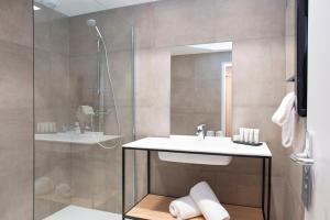 a bathroom with a sink and a shower at Domaine De Saint Clair Spa & Golf in Saint-Clair