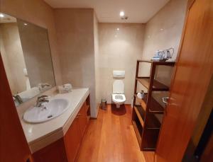 uma casa de banho com um lavatório e um WC. em T1 Sea & Pool em Caxias