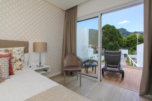 a hotel room with a bed and a balcony at Casa Nostra in Furnas