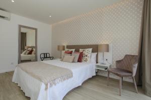 a bedroom with a large bed and a chair at Casa Nostra in Furnas