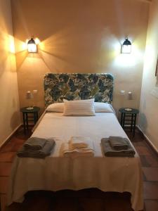 a bedroom with a large bed with towels on it at Casa rural Entreaguas in Villanueva de la Vera +58 photos
