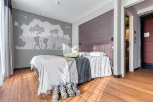 a bedroom with two beds and a wall at Le Merceny Motel in Bastogne