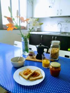 uma mesa azul com um prato de torradas e compota em Casa Grande Surf Hostel em El Médano