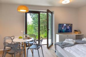 a bedroom with a bed and a table and chairs at Sun & Sport Apartamenty Krynica-Zdrój in Krynica Zdrój