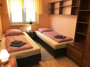 two beds in a small room with a window at Apartament ''Cleopatra'' z garazem podziemnym, faktury VAT in Kielce