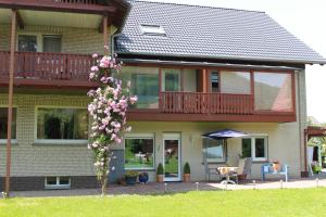 ein Haus mit einem Balkon, einem Tisch und Stühlen in der Unterkunft Ferienquartier Waldblick in Lügde