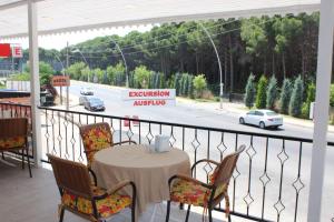 einen Tisch und Stühle auf einem Balkon mit Straßenblick in der Unterkunft Gül Otel in Belek