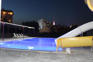 a swimming pool at night with a slide at Gül Otel in Belek