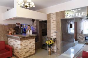 a woman standing at a bar in a hotel lobby at Hotelik Niedżwiadek in Radzyń Podlaski