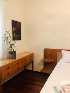 Un dormitorio con una cama y un tocador con una planta. en Casa Violante, en Verona