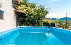 a blue swimming pool next to a building at Maison Peltrera in Como