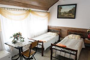 two beds in a room with a table and chairs at Hotelik Niedżwiadek in Radzyń Podlaski