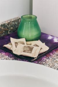 a green vase sitting on a table with napkins at Lovelyloft - Ripa Naviglio Grande in Milan