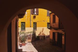 een boog die leidt naar een steeg met een geel gebouw bij Lovelyloft - Ripa Naviglio Grande in Milaan
