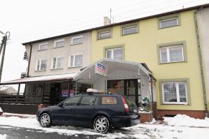 a black car parked in front of a building at Hotelik Niedżwiadek in Radzyń Podlaski