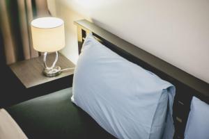 uma cama com uma almofada branca e um candeeiro em My Resort Beach Apartment em Hua Hin