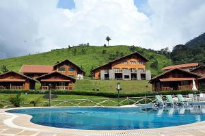 un complejo con piscina frente a una casa en Fazenda Suica Le Canton, en Teresópolis