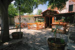 a patio with a table and chairs and a tree at Apartman Robi in Vrsine