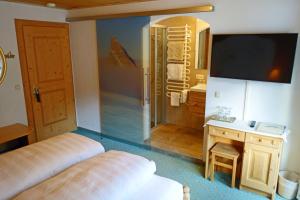 a bedroom with a bed and a bathroom with a television at Alkira in Sankt Anton am Arlberg