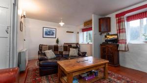 ein Wohnzimmer mit einem Sofa und einem Tisch in der Unterkunft Bryn Llys Uchaf in Capel-Curig