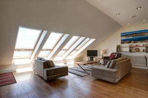 a living room with skylights and two chairs and a television at The Stables 1 - Llyn Peninsula in Nefyn