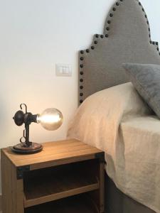Una cama con una mesa con una lámpara. en Trulli Pietraverde, en Ceglie Messapica