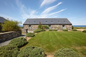 a stone house with a lawn in front of it at The Stables 1 - Llyn Peninsula in Nefyn