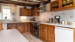 una cocina con armarios de madera y electrodomésticos blancos en Maes Glas, en Mallwyd 19 fotos más